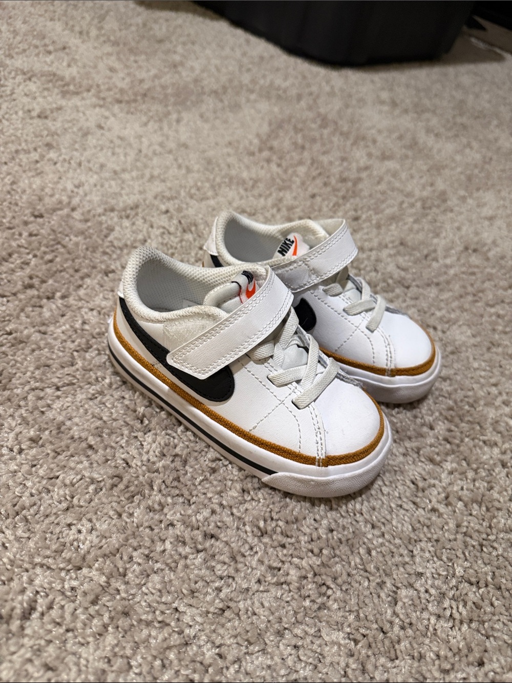Nike Kids White Sneakers with Black Swoosh and Gold Accent